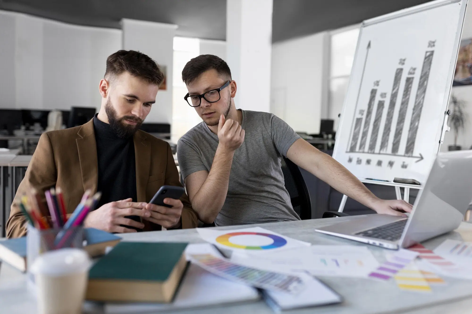 Männer, die gemeinsam bei der Arbeit ein Diagramm analysieren.